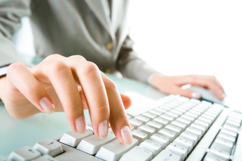 female worker typing at keyboard fingers